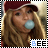 A woman with long blonde hair and a maroon cap blows a light blue bubble gum bubble, with a pixelated 'BEE' text overlay in the lower right corner.