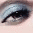 A split-frame image shows a close-up of an eye with dark eyeliner on the left and stylized text on a blue background on the right.