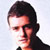 Pixelated static image of a person's face with dark hair and light skin, cropped to show only the upper head against a plain background.