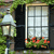 Static pixel art of a window with a flower box, a streetlamp, and greenery, rendered in a low-resolution, blocky style.