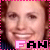 Pixelated image of a person with light brown hair and fair skin, wearing a dark blue top, smiling broadly across four with pink dotted borders