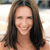 A static pixelated image of a person with long brown hair, closed eyes, and a smiling expression against a light background.