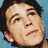 Pixelated close-up of a person's face with dark hair against a blue background, rendered in low-resolution 48x48 pixels.