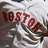 Red pixelated text reading 'BOSTON' on a light background with dark brown and gray shapes below.