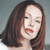 Pixelated close-up of a person with long brown hair, closed eyes, and red lips against a muted gray background.