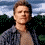 A pixelated image of a person in a denim jacket against a sky and tree background, with a black containing text on the right
