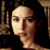 Two side-by-side pixelated frames of a person with dark hair against a bookshelf background, showing subtle facial expression changes between the left and right frame.