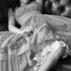 Black-and-white image of a person in flowing fabric with arms raised, partially cropped at edges.