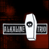Animated icon featuring a white coffin with a skull face, positioned over a black-and-white banner reading 'ALKALINE TRIO' against a red and black background.