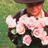 Static image of pink and white roses with green foliage against a blurred background.