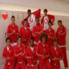 Group of people in red and white outfits posing in front of lockers with heart symbols appearing and disappearing.