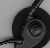 Black-and-white pixelated image of a circular object with concentric rings and a curved extension on the left side, set against a light gray background.