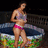 A pixelated image of a woman in a bikini standing by a pool, with a pink text overlay reading "LeOnShiIA" on the right side.