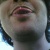Pixelated close-up of a person's face showing eyes, nose, and mouth with visible skin tones and dark hair strands.