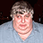 Pixelated image of a person with light brown hair and gray shirt on left, bright green background with blue text reading "i am a chool kid & you are all shlags peace don vito ha ha:]" on right.
