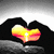 Animated icon shows hands forming a heart shape with a sunset scene inside, transitioning to a beach scene with palm trees and water.