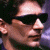 A split-frame contact sheet showing a pixelated close-up of a person wearing dark sunglasses on the left and green text reading "Original Icons .com" on a solid green background on the right.