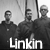 Five individuals in dark clothing stand side-by-side with a blurred background, text "Linkin" and "Park" overlaid at the bottom.