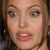 A pixelated close-up of a person's face showing eyes, nose, mouth, and brown hair against a dark background.