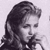 Static grayscale pixel art of a person with long wavy hair in profile view, rendered at low resolution with dithering and anti-aliasing effects on a light background.