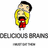Pixelated cartoon character with black hair and yellow face, mouth open wide showing red interior, holding small red object. Text below reads 'DELICIOUS BRAINS' in gray block letters.