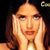 Static pixelated image of a person with long hair and hands near face against dark background, likely celebrity reference.