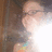 Pixelated close-up of a person's face with brown hair, light skin, and a blurred background showing partial clothing colors.