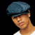 Pixelated static image of a person wearing a blue flat cap and white shirt against black background, cropped to show head and shoulders with slight angle toward camera.