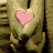Animated sequence showing a golden hand with pink heart, then two hands forming hearts, and finally a heart drawn in sand.