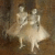 Pixelated static image of two light-colored figures in a dynamic pose against a brownish background with visible pixelation and low resolution.