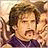Pixelated image of a man with brown hair and mustache, wearing dark clothing, overlaid with blue text reading "No one makes me bleed my own blood" on white background.