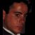 Pixelated image of a person with dark hair and light skin, wearing a white-collared shirt against black background on left side; green text 'Original Icons .com' in pixelated font on right.