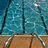 Pixelated image of a swimming pool with metal railings and wooden deck, surrounded by blue background text reading "swim hard," "swim fast," and "swim 4 life."