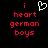 Pixelated text and a heart symbol on black background, with red lowercase letters spelling 'i heart german boys' and white pixel-art heart above the word 'heart'.