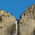 Two pixelated rock formations with a narrow vertical gap between them under a solid blue sky background.