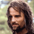 Pixelated close-up of a person with long brown hair, closed eyes, and a neutral expression against a blurred background.