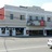 A pixelated static image of a building facade with multiple windows and a red accent on the left side.