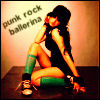 A woman in a black outfit and green socks poses with one hand near her face, against a wall with text.