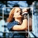 A woman with long red hair in a blue top holds a microphone, transitioning from full-body to star-shaped crop.