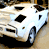 A 49x49 pixel animated contact sheet showing two frames of a beige car icon with white accents, viewed from the front-left angle on a gray background.