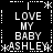 Black background with white pixelated text reading "LOVE MY BABY ASHLEY" arranged in a pattern, surrounded by decorative asterisks and dotted lines