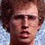 A pixelated image of a person with light brown hair and glasses, surrounded by text variations including 'heck', 'Y', 'YE', 'YES', 'I did', '...', and 'GOSH' in blue font.