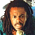 Pixelated portrait of a person with long dark hair, light skin, and a neutral expression, wearing a light-colored top against a blurred background.