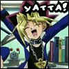 Animated character with blonde hair and blue jacket shouting 'YATTA!' in a room with bookshelves, alarm clock, and books.