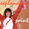 A person in a red jacket and white shirt with a red exclamation mark holds up a red-and-white checkered pom-pom, with 'explanation' and 'point' text overlays.