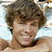 A pixelated image of a person with light brown hair and no shirt, positioned on the left side of a black background.