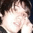 A person with dark hair appears in three distinct poses: smiling while covering mouth, neutral side profile, and looking downward.