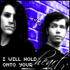 Two people stand against a purple brick wall with text reading "I WILL HOLD ONTO YOUR" and heart symbols above them.