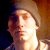 Pixelated static image of a person's face with warm lighting and blurred background, likely from an 8-bit or low-resolution source.