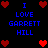 Pixelated blue text reads 'I LOVE GARRETT HILL' surrounded by red heart symbols on a black background with animated heart changes.
